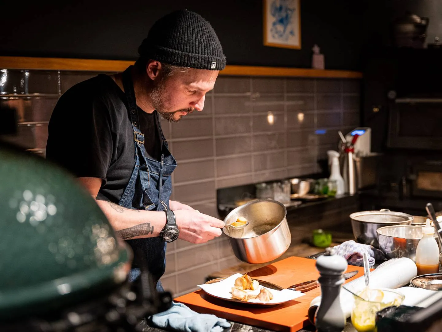 Szene eines Kochs bei der Zubereitung in einer modernen Küche. Authentisches Food-Branding-Motiv für Gastronomie, Storytelling und Markeninszenierung.