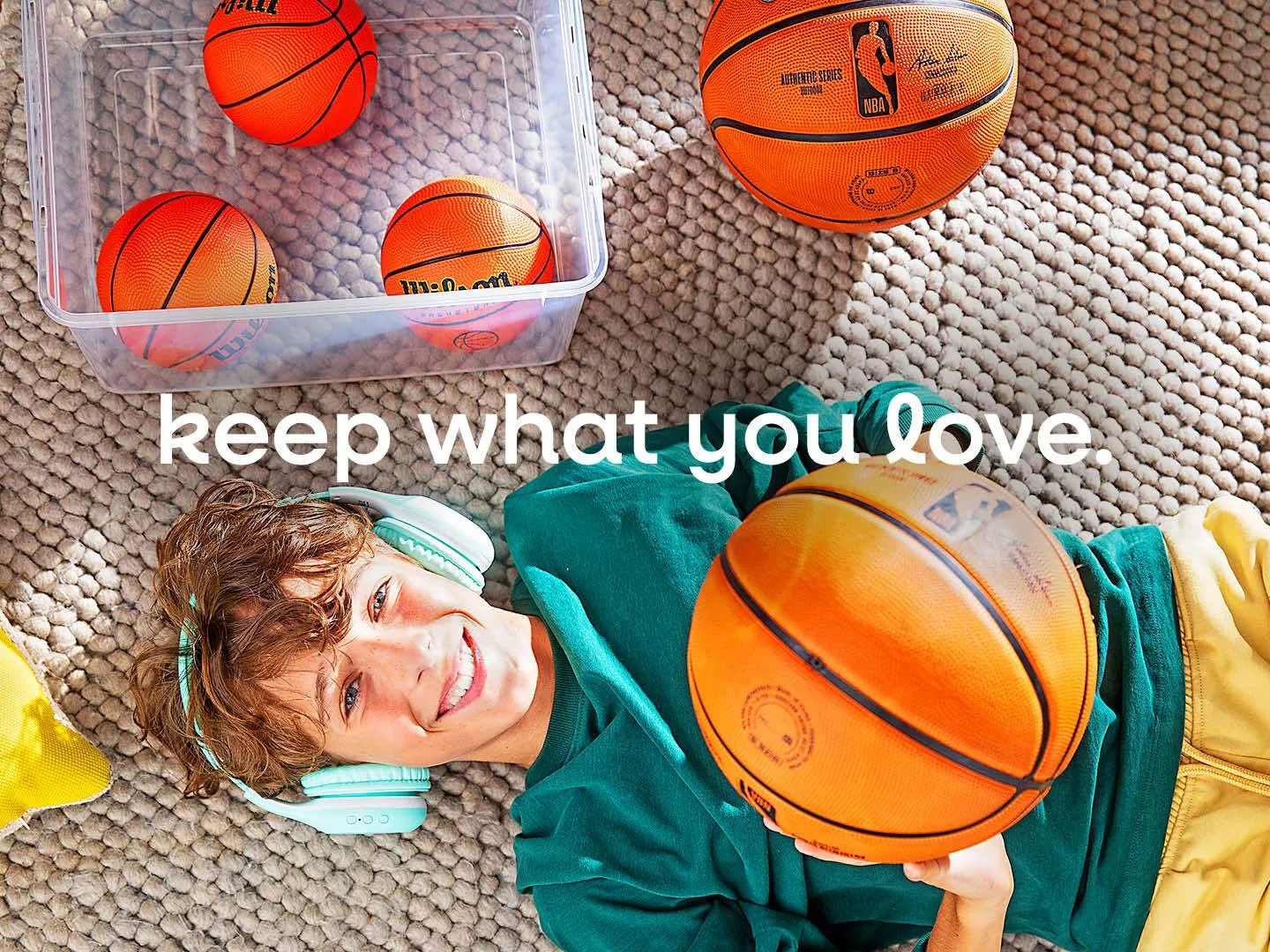 Junge Person mit Kopfhörern hält Basketball, daneben keeeper Aufbewahrungsbox. Authentisches Keyvisual für Lifestyle- und Marken-Kampagnen.